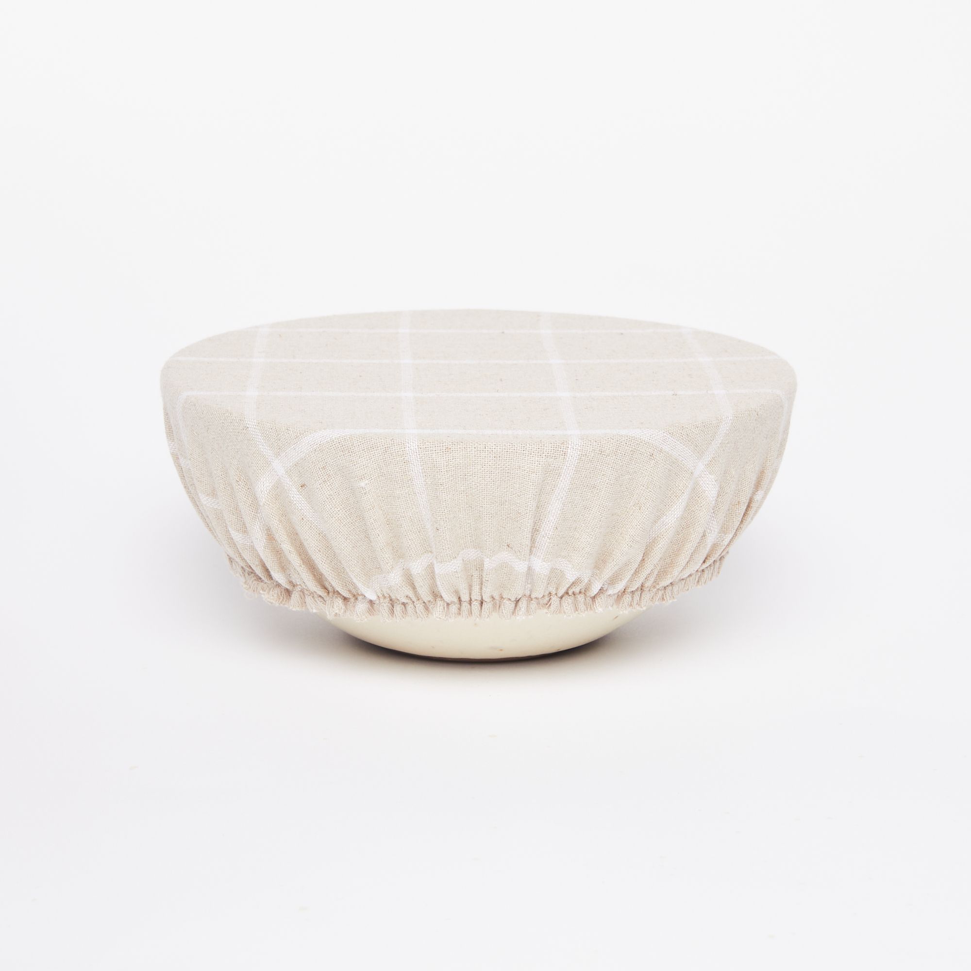 Soup bowl with light tan linen bowl cover with large white grid design