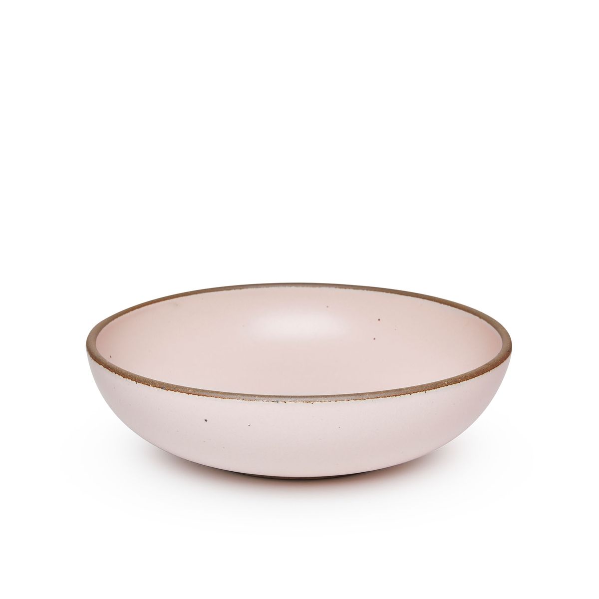 A large shallow serving ceramic bowl in a soft light pink color featuring iron speckles and an unglazed rim