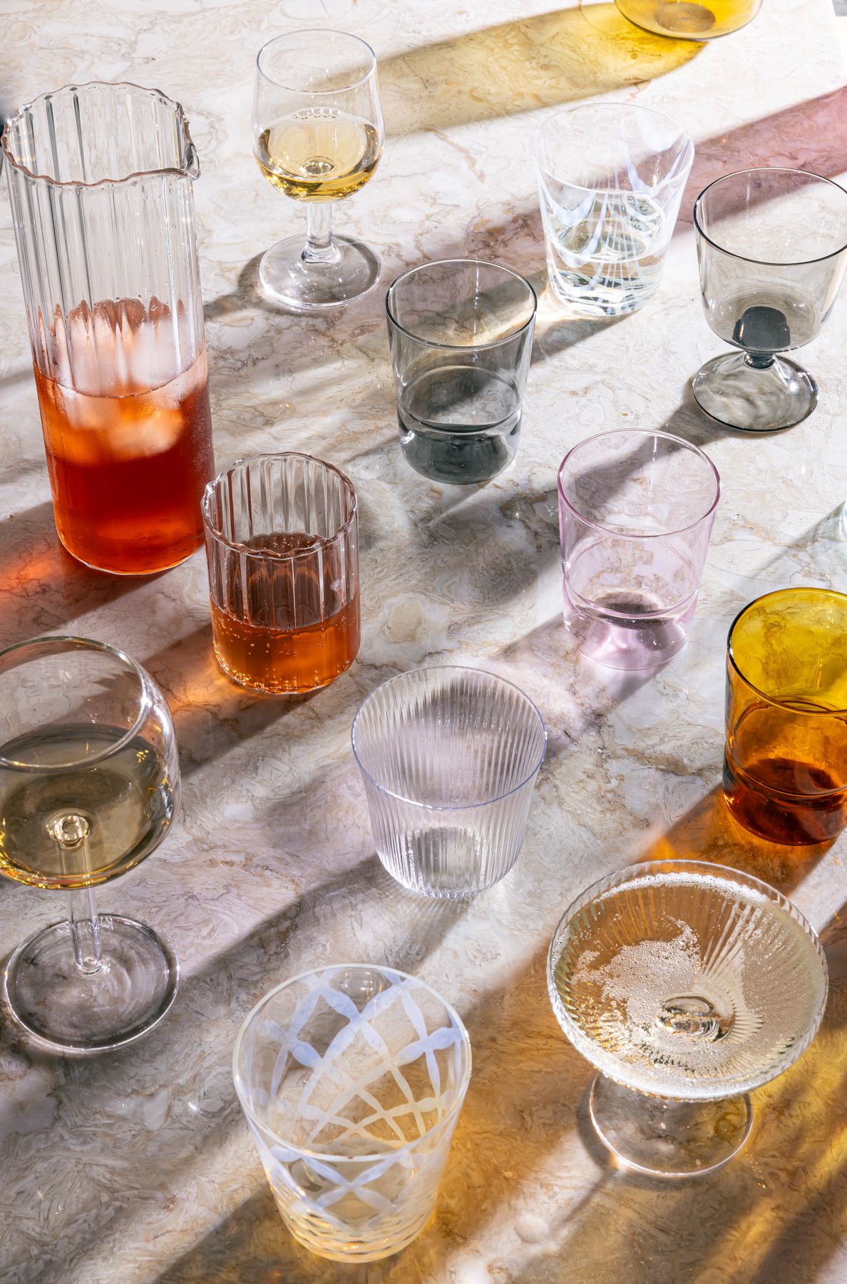 Various types of drinking glassware all next to each other with artful shadows casting.