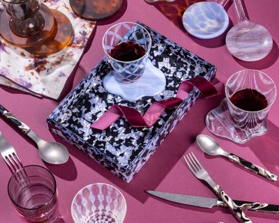 An artful arrangement of items with fun patterns and textures including glassware, an acrylic tray, sophisticated flatware and more.