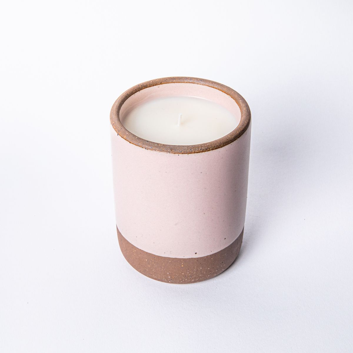 Large ceramic vessel in soft light pink color with candle inside