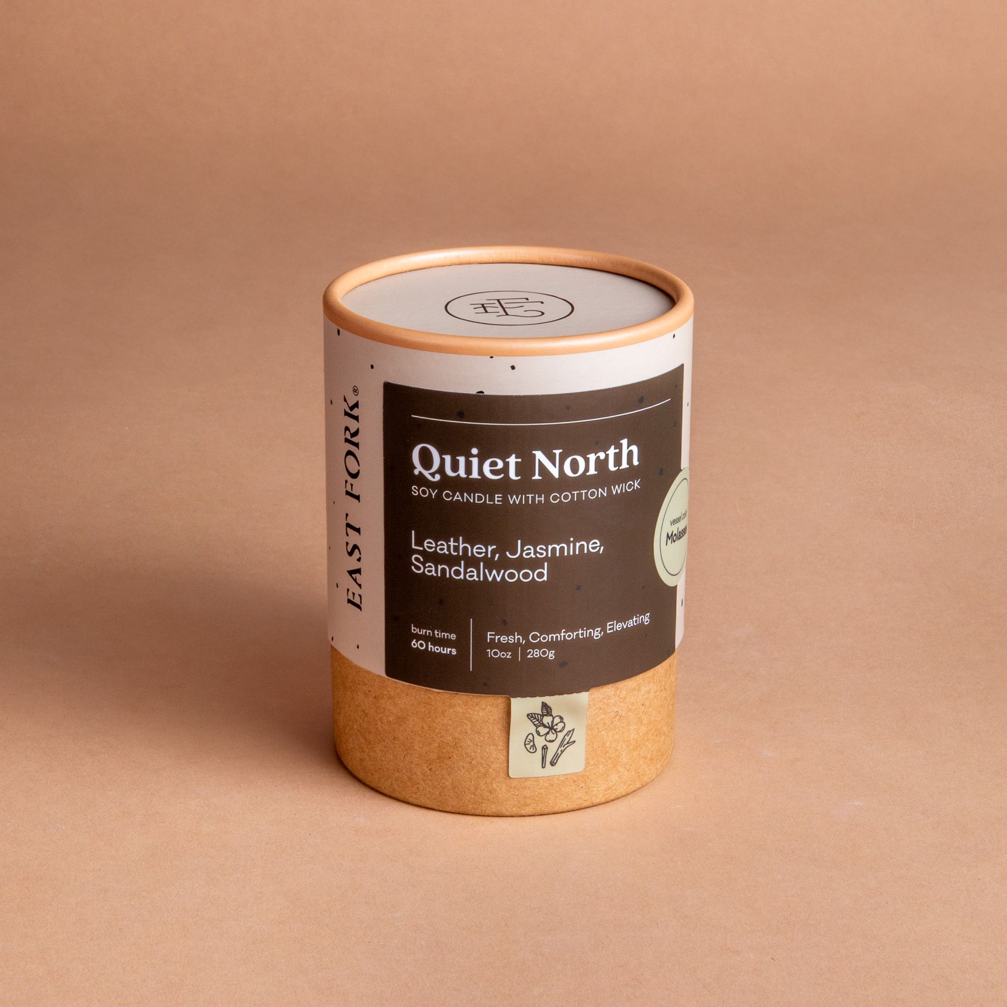 Large cardboard packaging tube with a candle inside with branding on it that says 'Quiet North'