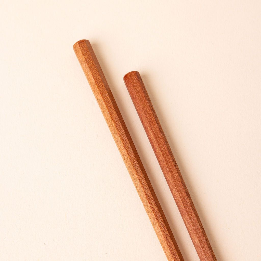 Hexagonal tip of simple pair of light brown wood chopsticks