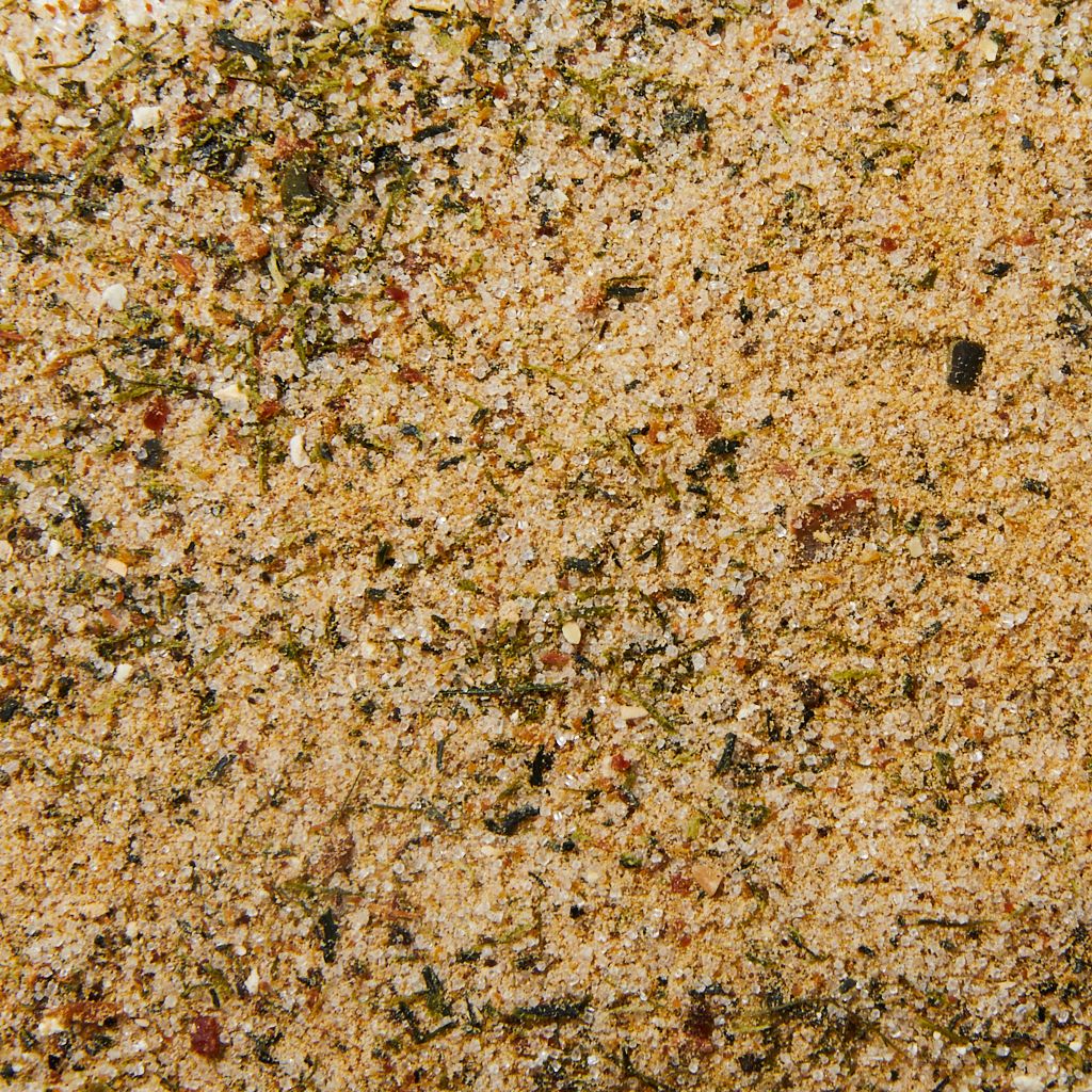 Closeup of dashi, mostly tan with flecks of green, white and orange