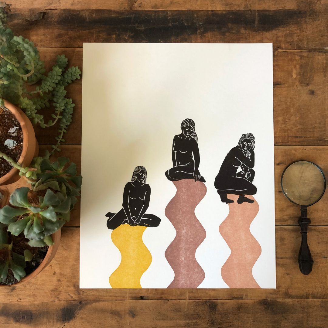 Art print with three seated figures over wavy color shapes on a wooden surface, surrounded by potted plants and a magnifying glass
