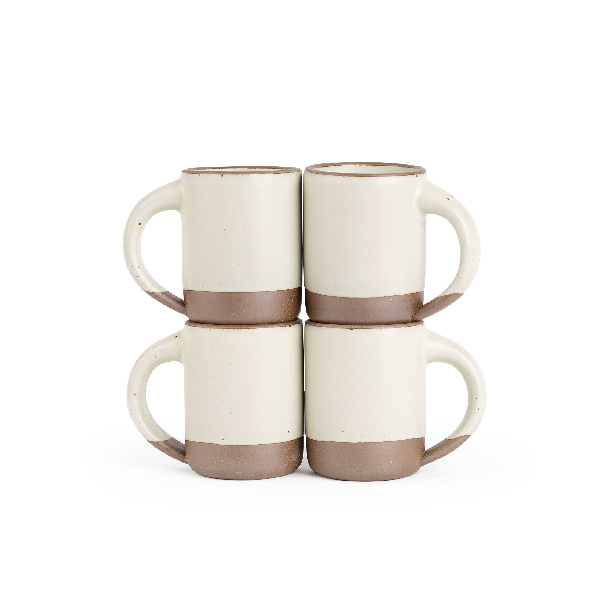 Four medium sized ceramic mugs with handles in a warm, tan-toned, off-white color featuring iron speckles and unglazed rim and bottom base, stacked in sets of 2.