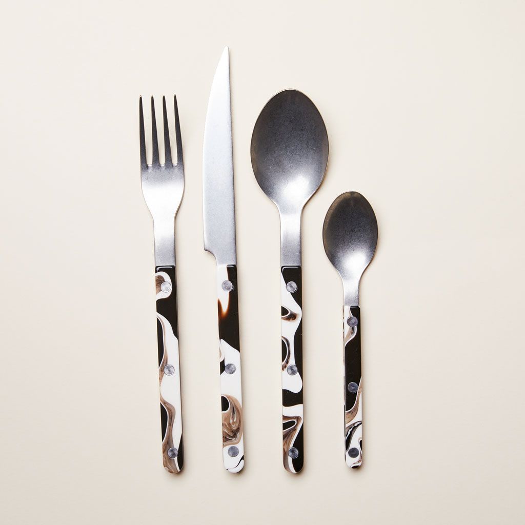 A group of silver, white and gray cutlery (fork, knife, soup spoon and teaspoon)