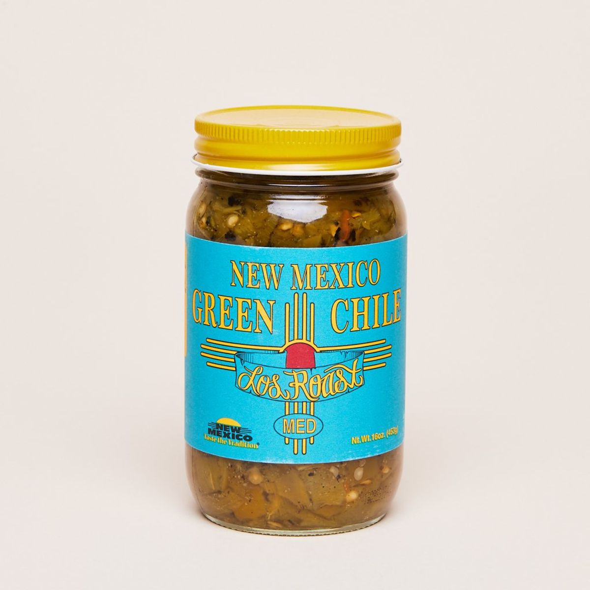 New Mexico Green Chile in a tall glass bottle with a yellow lid