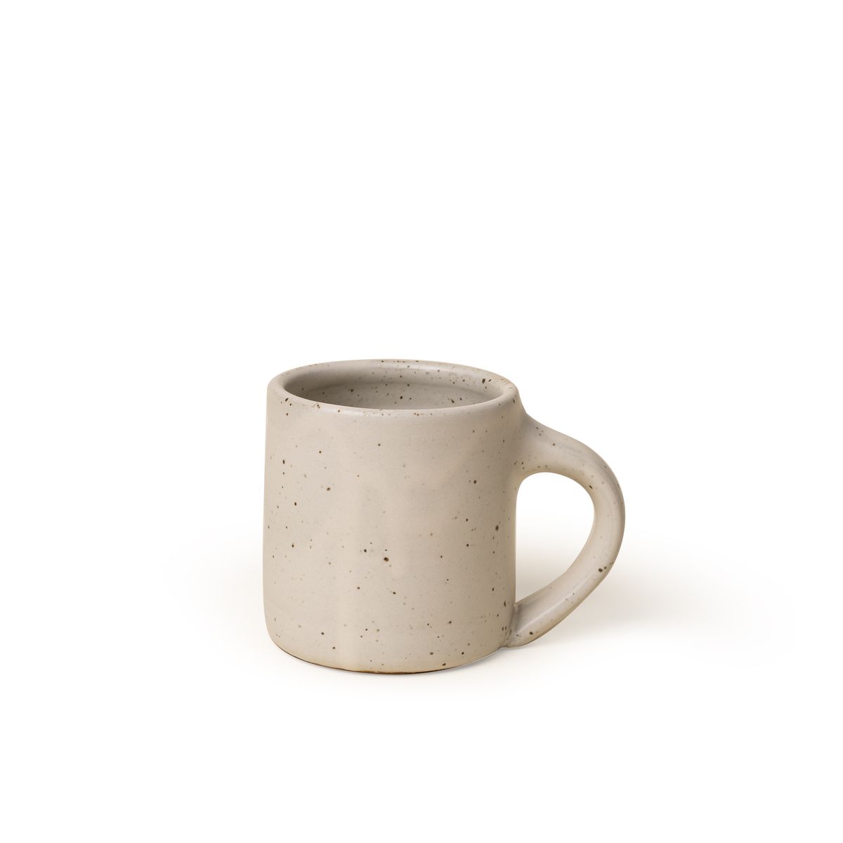 A medium sized ceramic mug with handle in a warm, tan-toned, off-white color featuring iron speckles