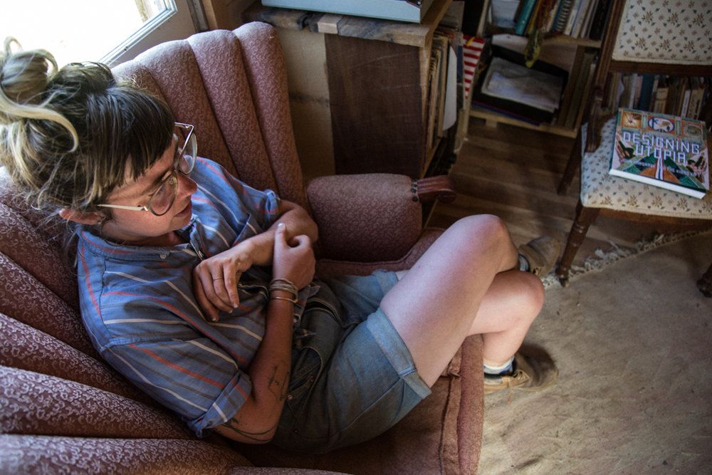 A woman sits on a chair in a living room