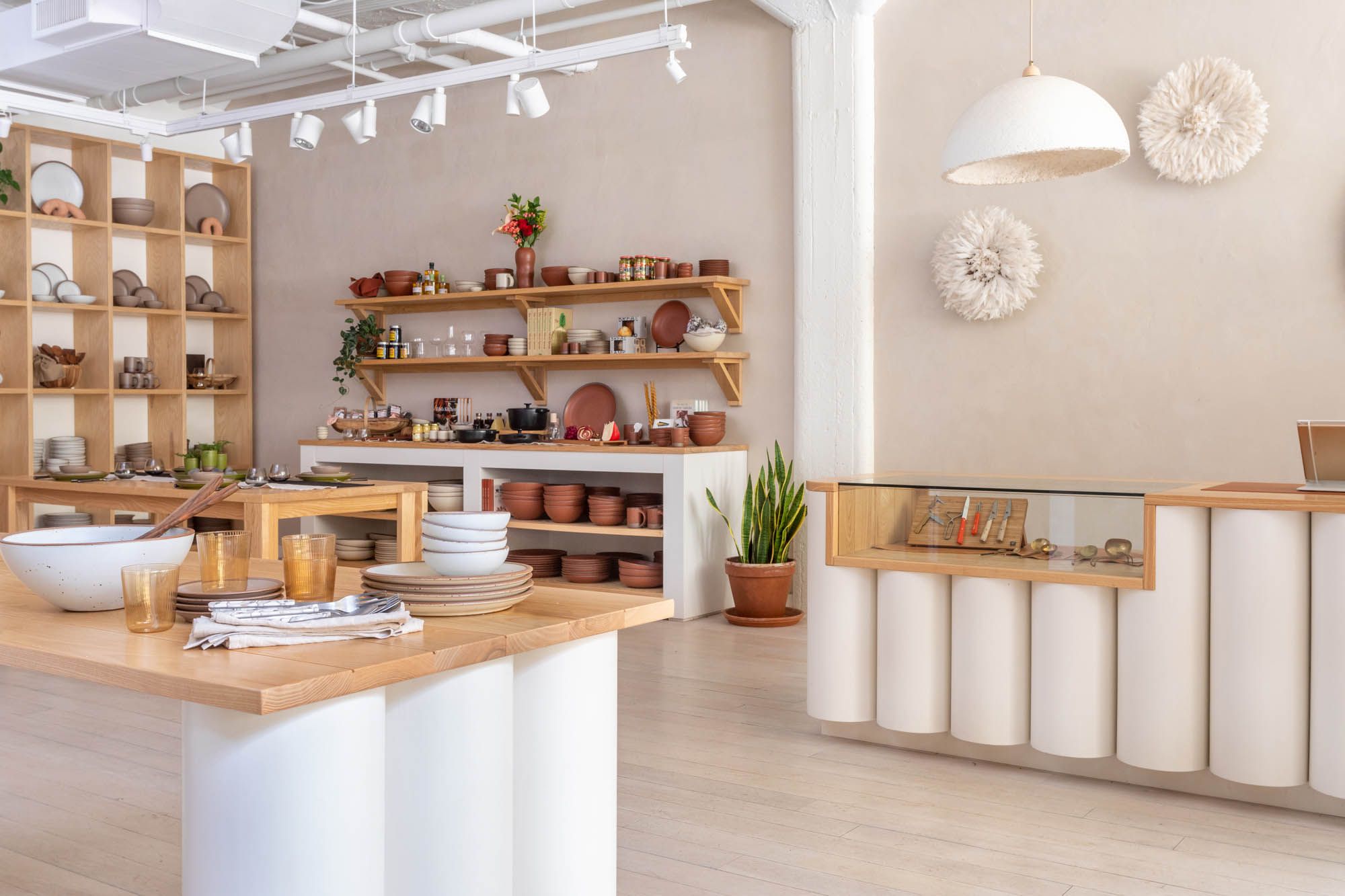 Inside East Fork Atlanta, filled with artful tables and a cash wrap, wall shelves with pottery and a beautiful checkerboard shelf with pottery and other objects