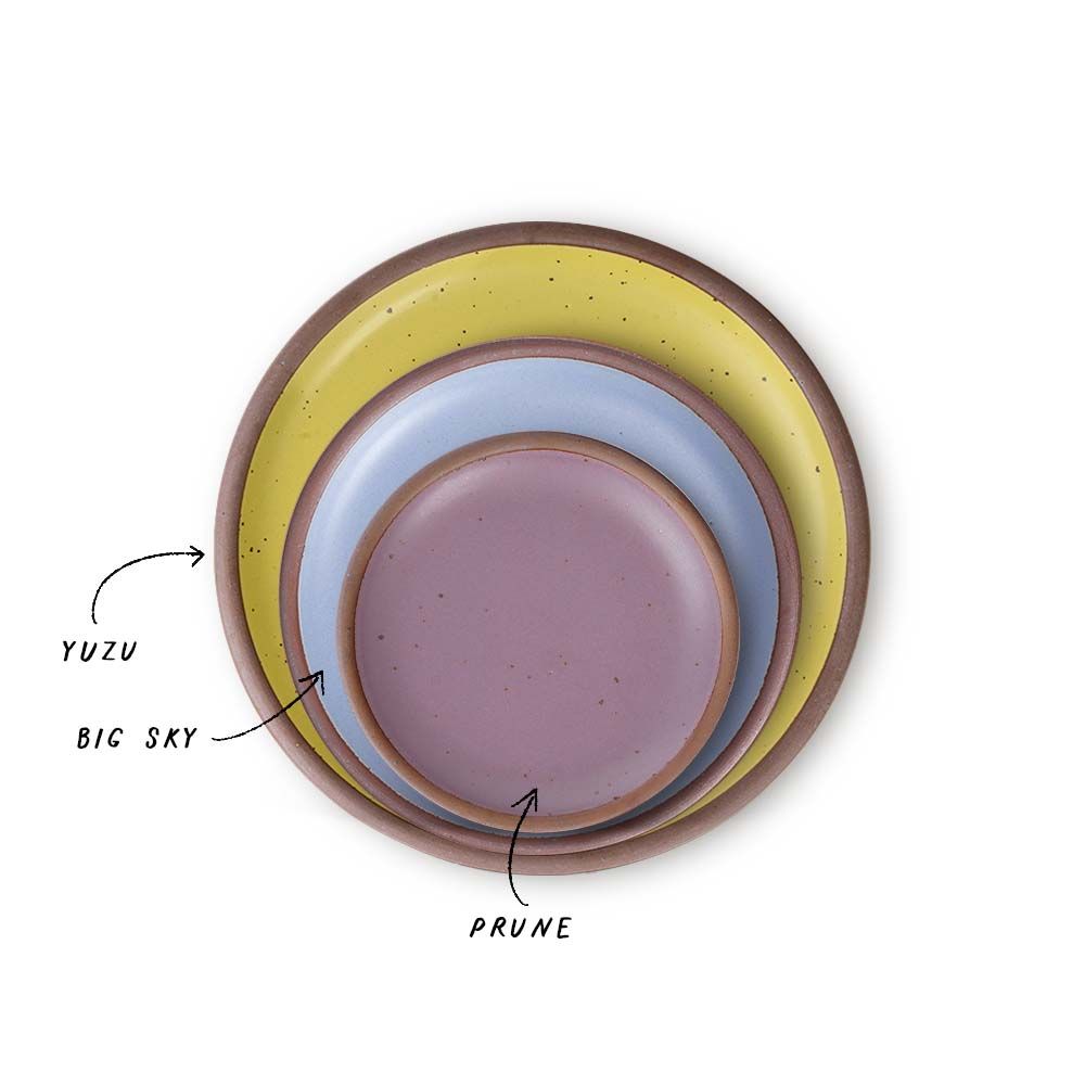 A stack of 3 plates in Dinner, Side, and Cake sizes in a zesty yellow, periwinkle, and soft mauve purple colors.