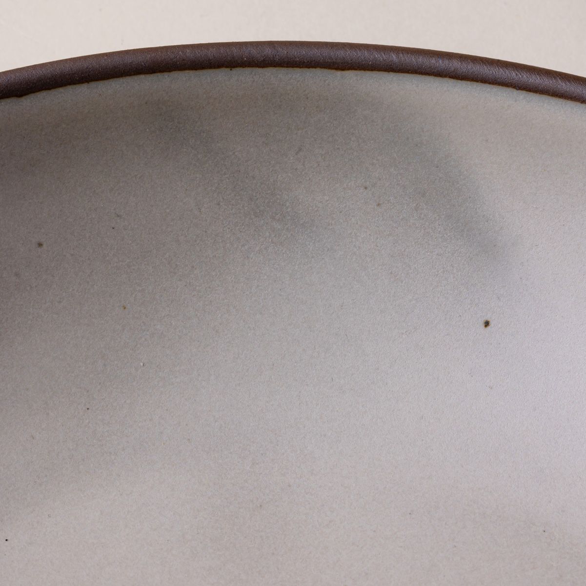 Streaky glaze on a ceramic bowl in a cool white color.