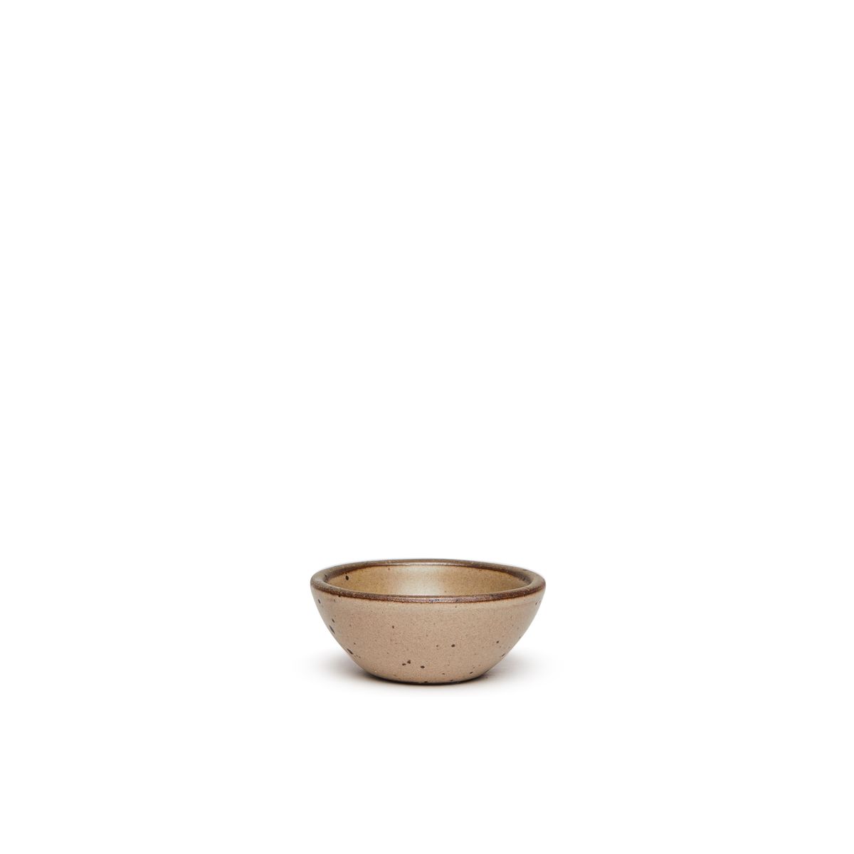 A tiny rounded ceramic bowl in a warm pale brown color featuring iron speckles and an unglazed rim