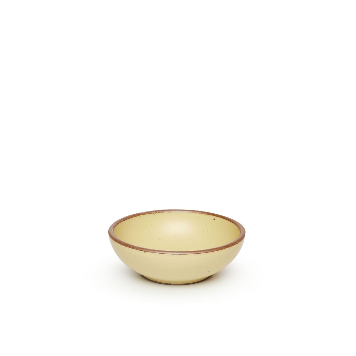 A small shallow ceramic bowl in a light butter yellow color featuring iron speckles and an unglazed rim