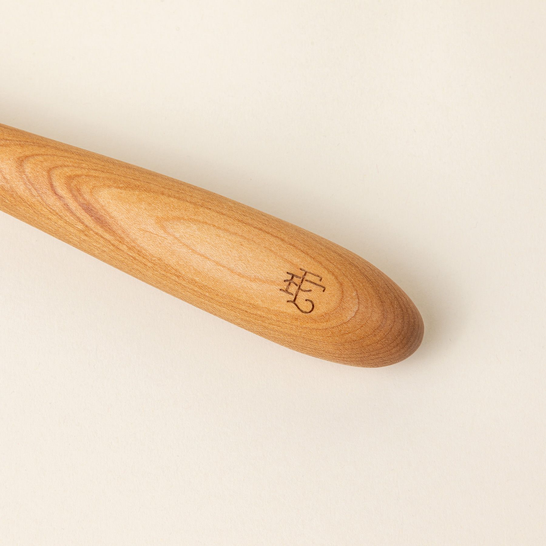 A stamp of the East Fork logo on the end of a wood ladle.