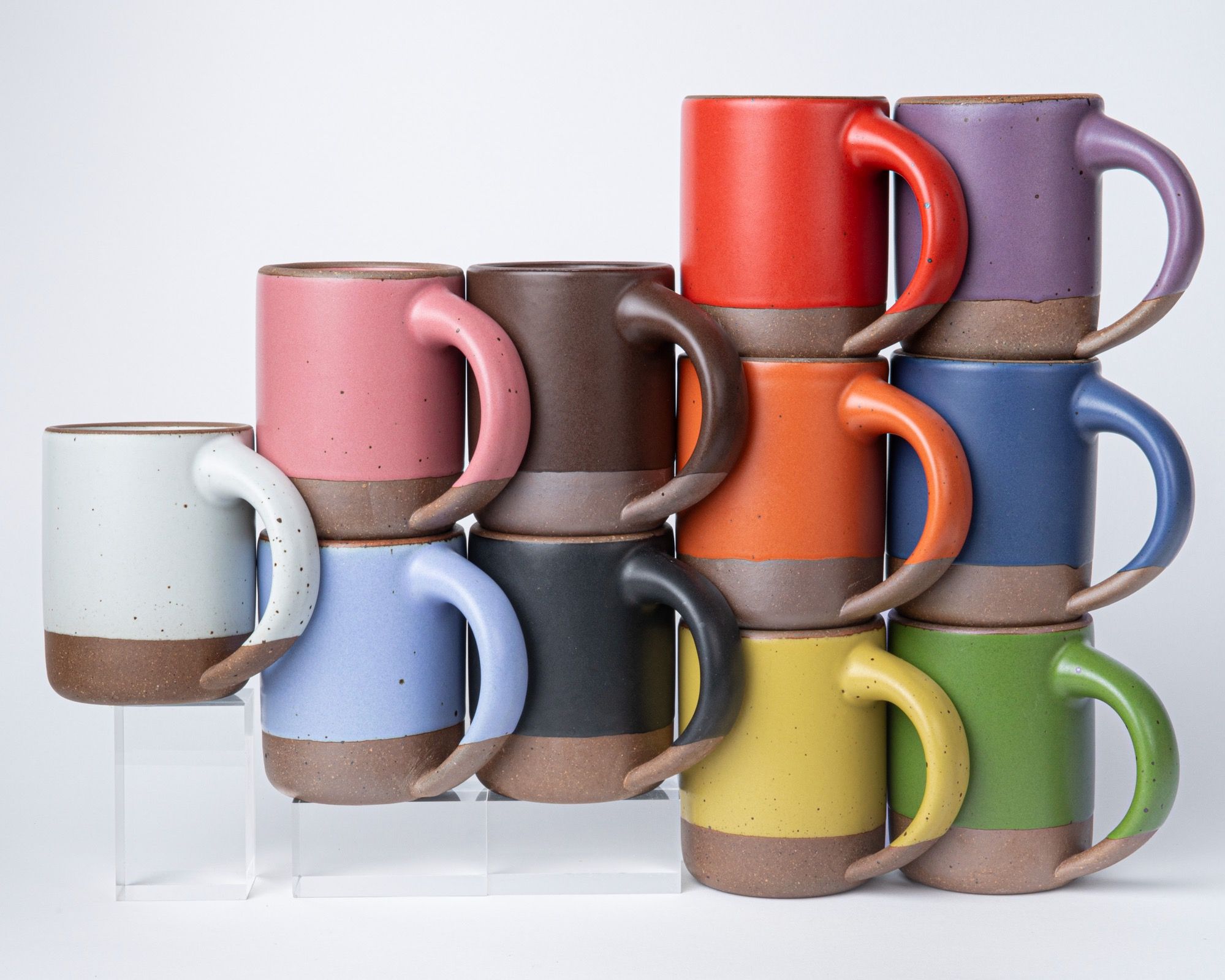 Colorful ceramic mugs are formed in a triangle to symbolize the Progress Pride flag.