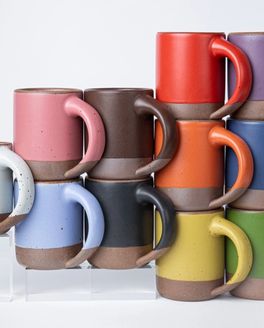 Colorful ceramic mugs are formed in a triangle to symbolize the Progress Pride flag.