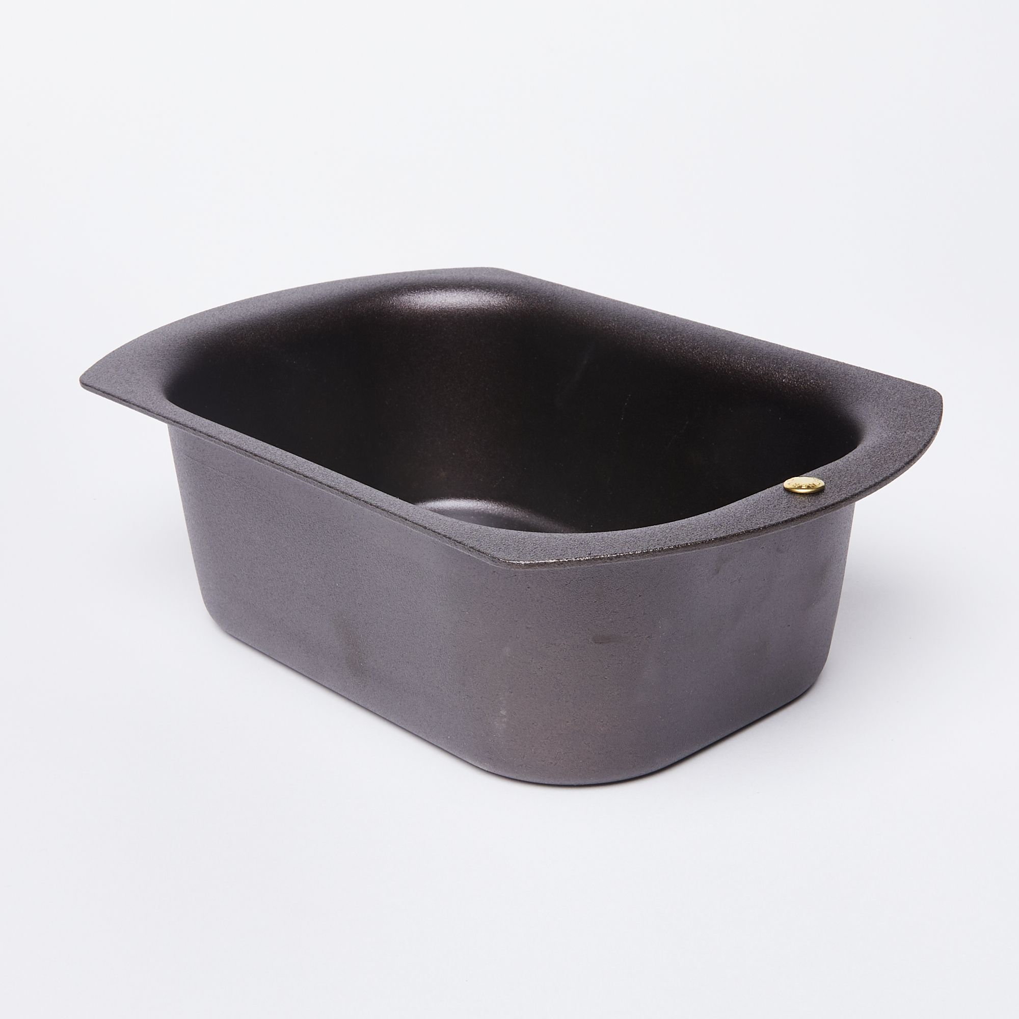 A black metal loaf pan with rounded corners and a wide flat lip
