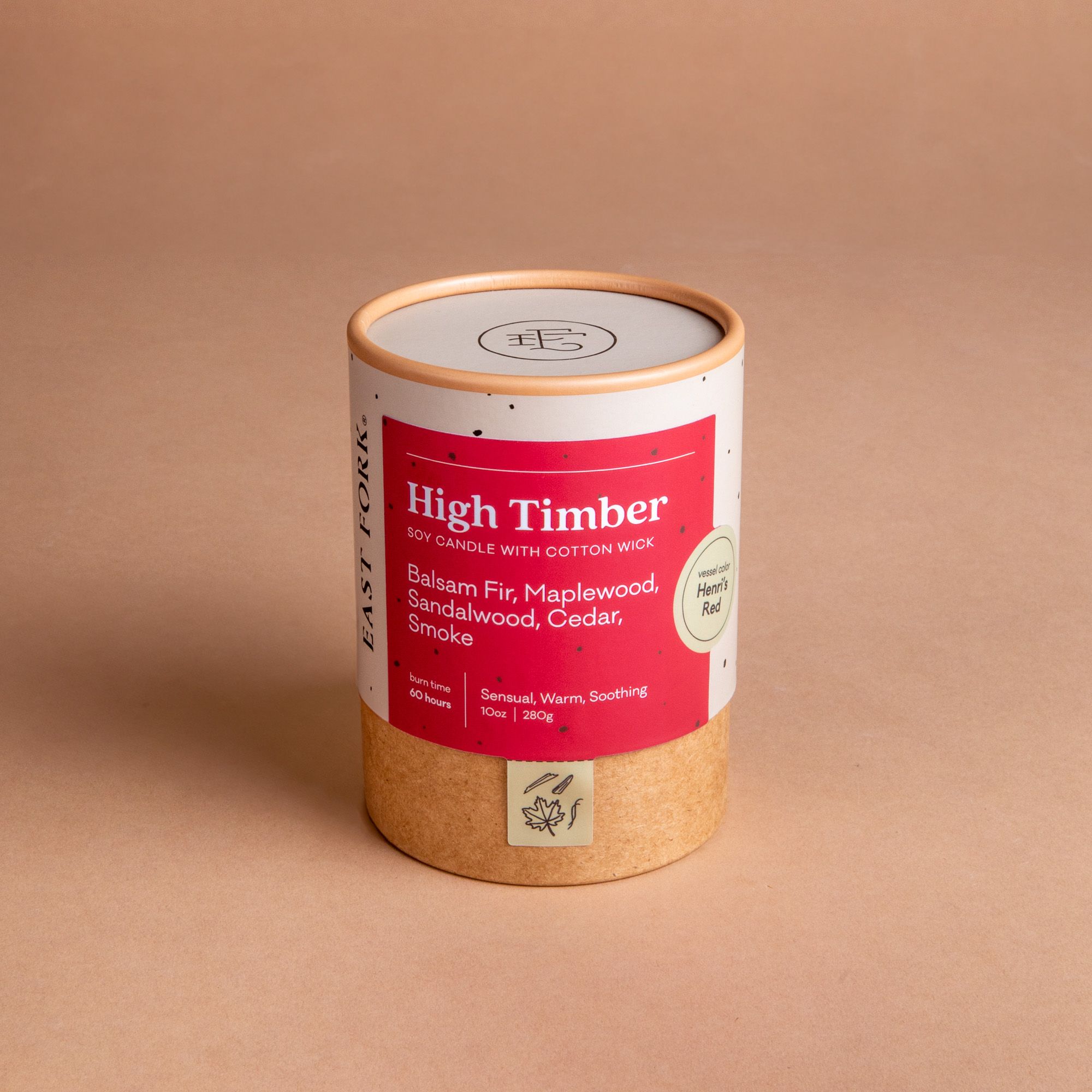 Large cardboard packaging tube with a candle inside with branding on it that says 'High Timber'