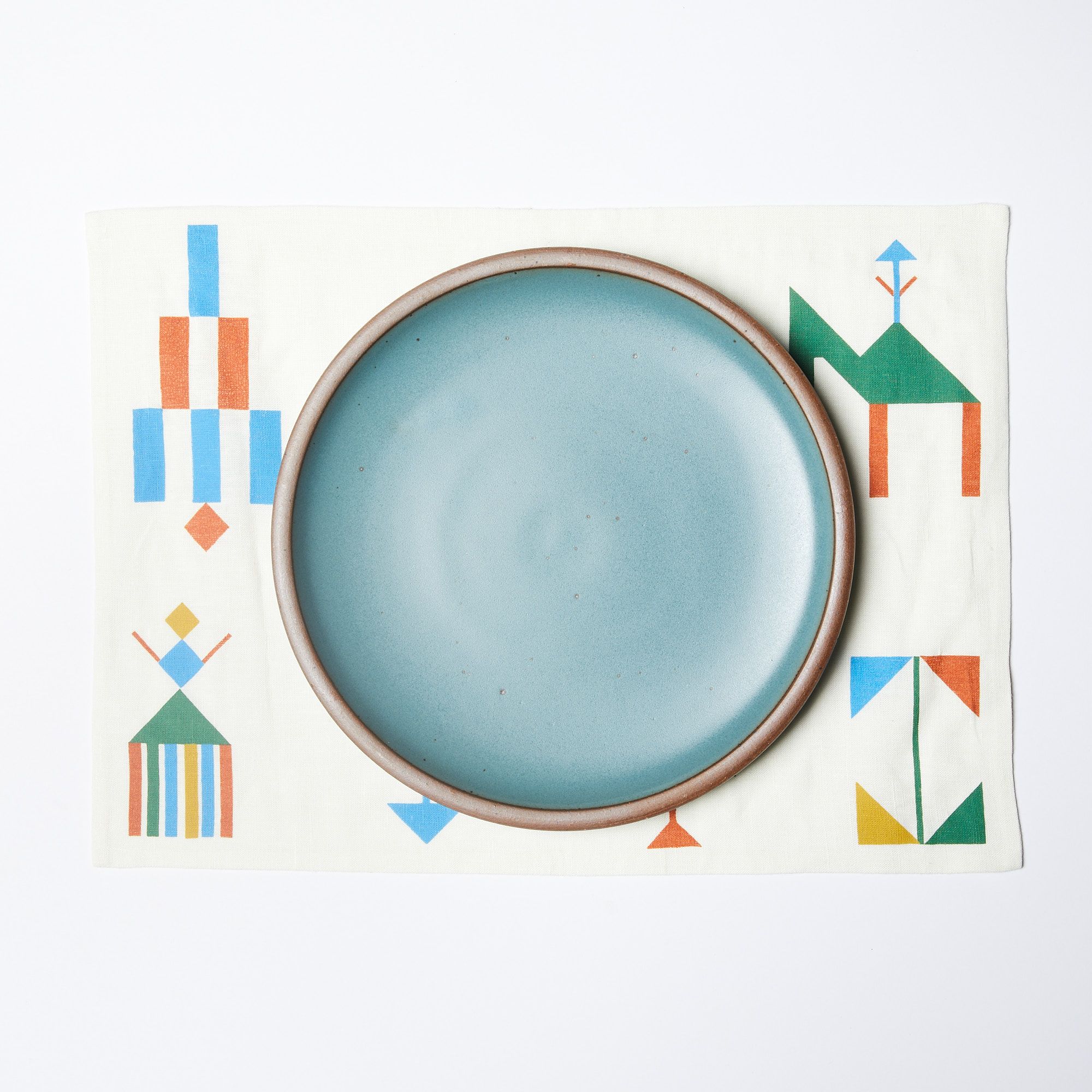 cream placemat with decorative festival images and a secret beach plate on top