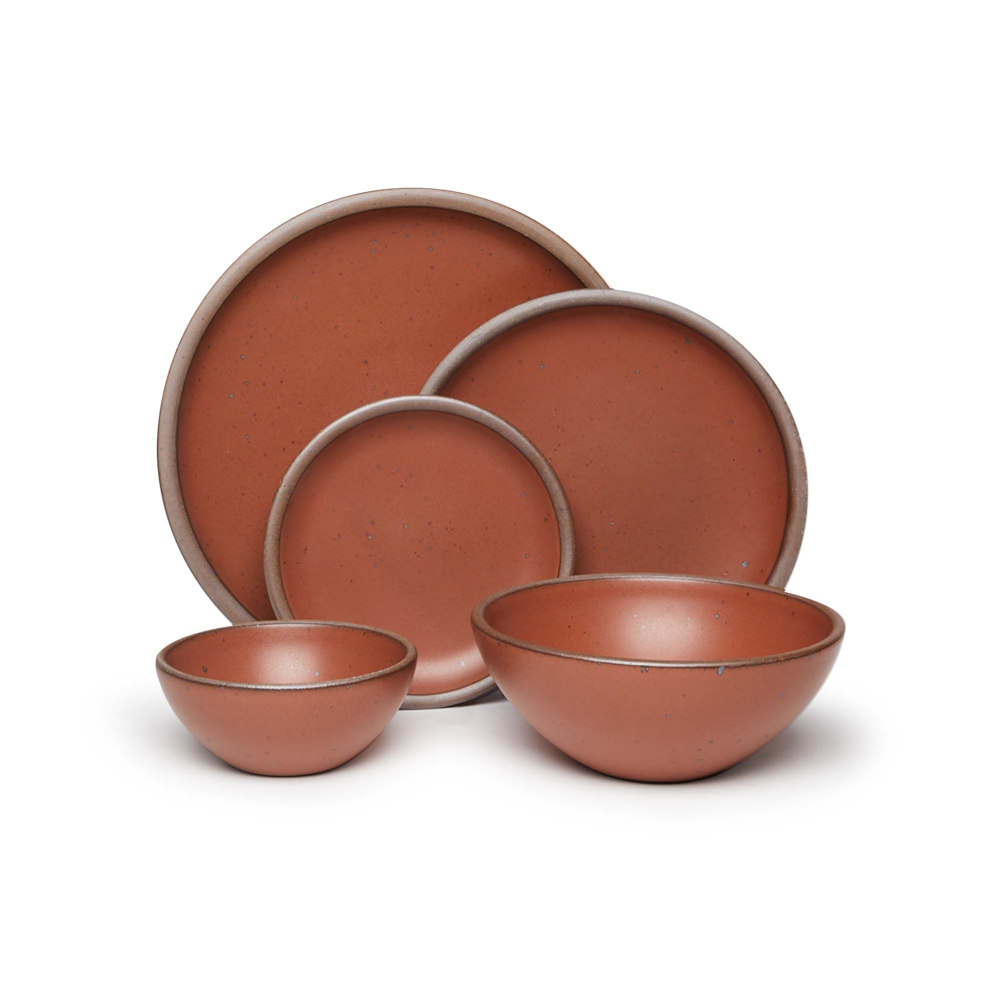 An ice cream bowl, soup bowl, cake plate, side plate and dinner plate paired together in a cool burnt terracotta featuring iron speckles