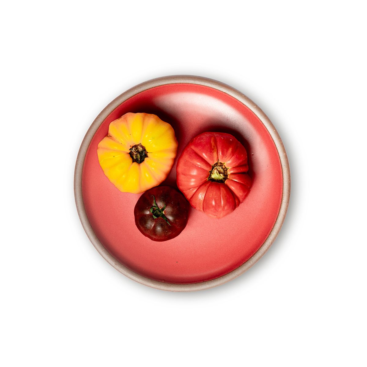 Three little gourds on a dinner sized ceramic plate in a bold red color featuring iron speckles and an unglazed rim