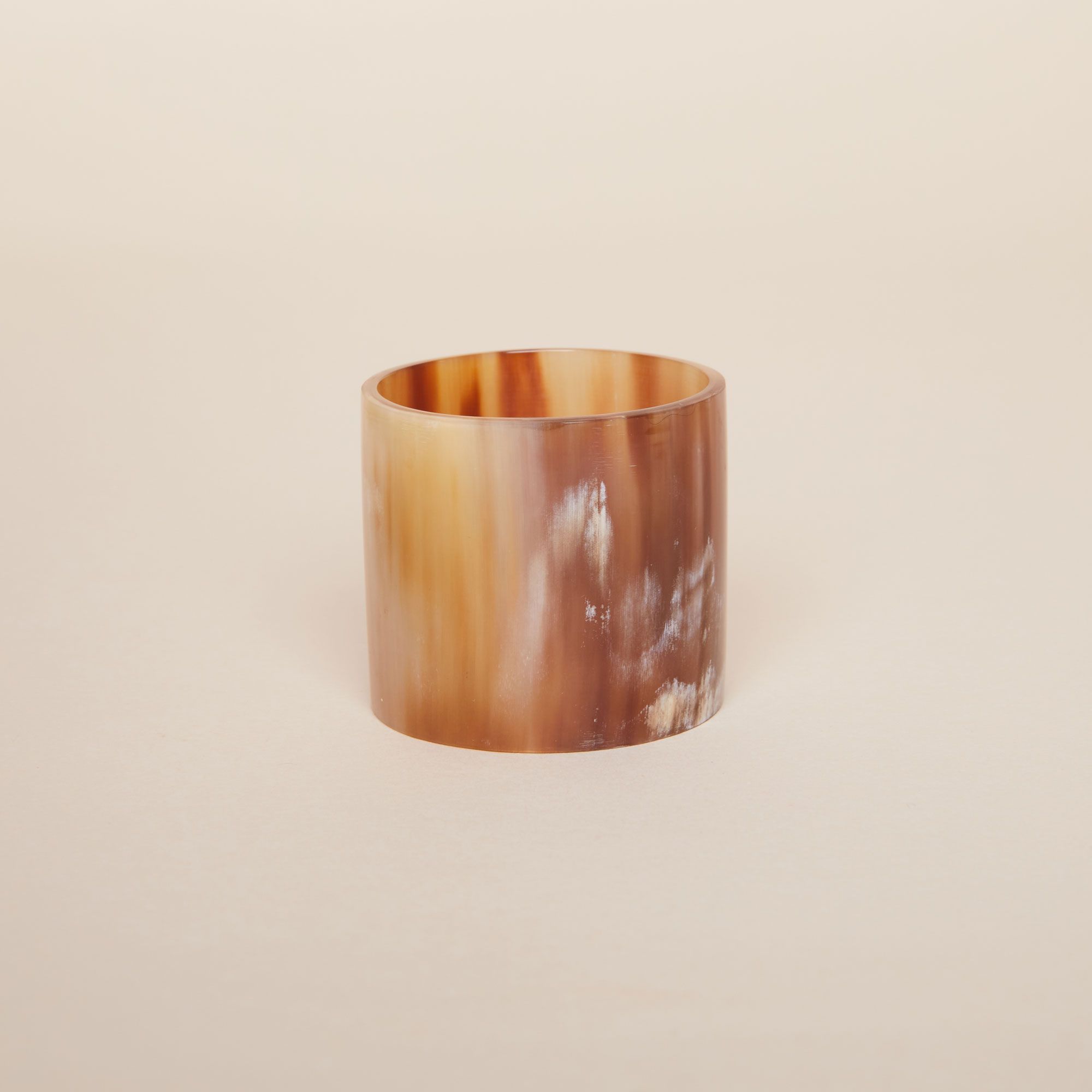 One cylindrical napkin ring with a varigated stripe pattern in browns and whites