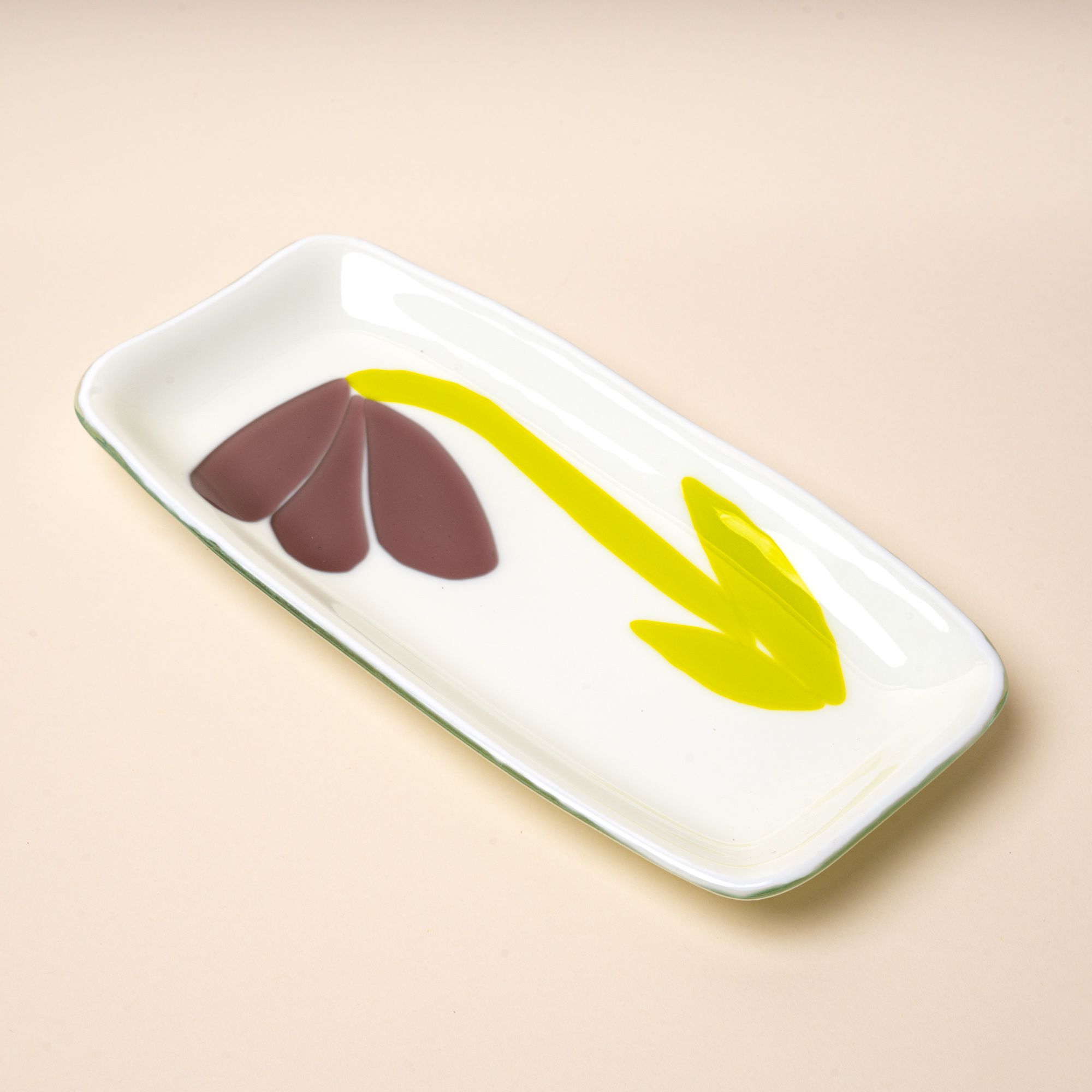 A white rectangular glass catchall tray with a design featuring a minimal purple flower with green stem.