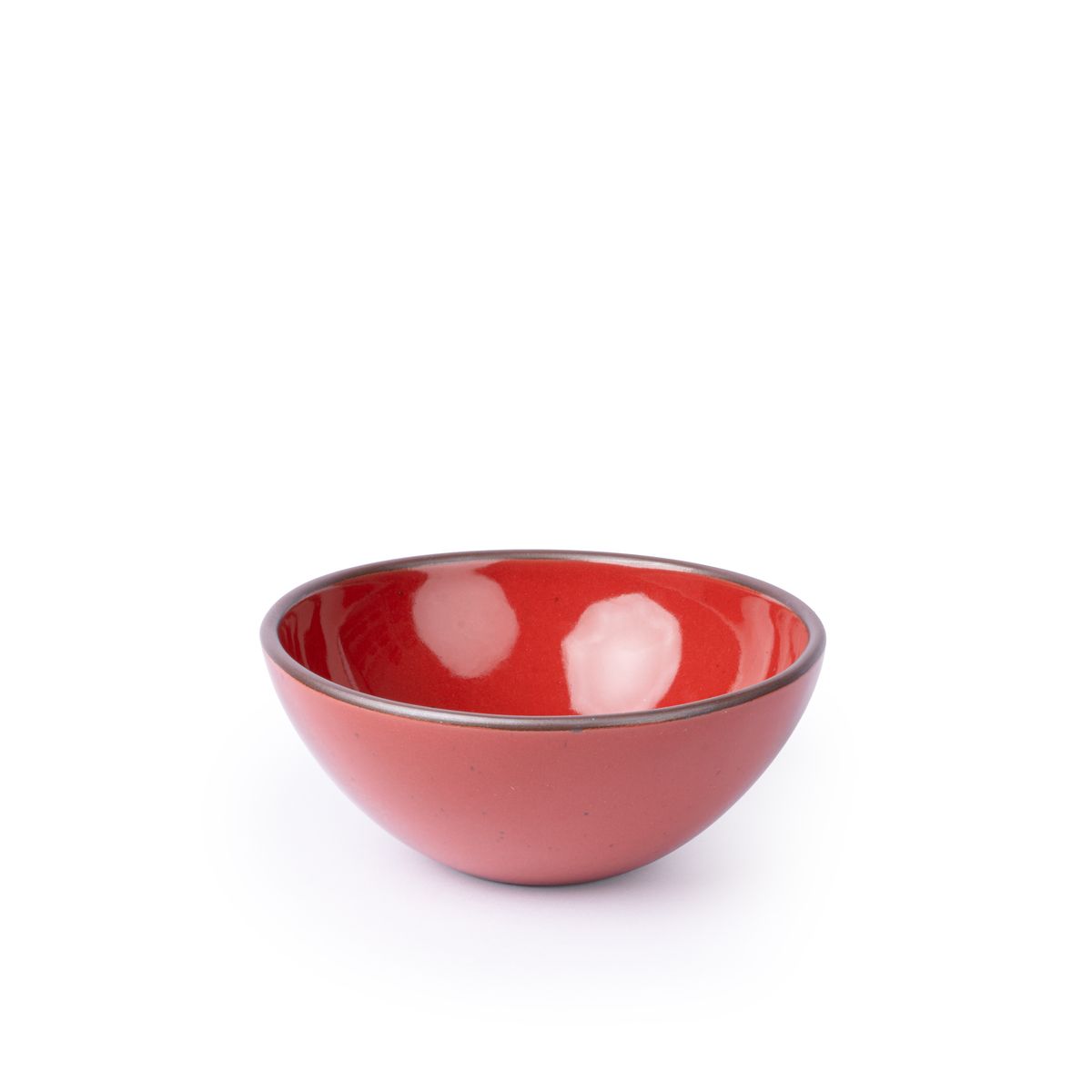 A medium rounded ceramic bowl in a glossy red color featuring iron speckles and an unglazed rim