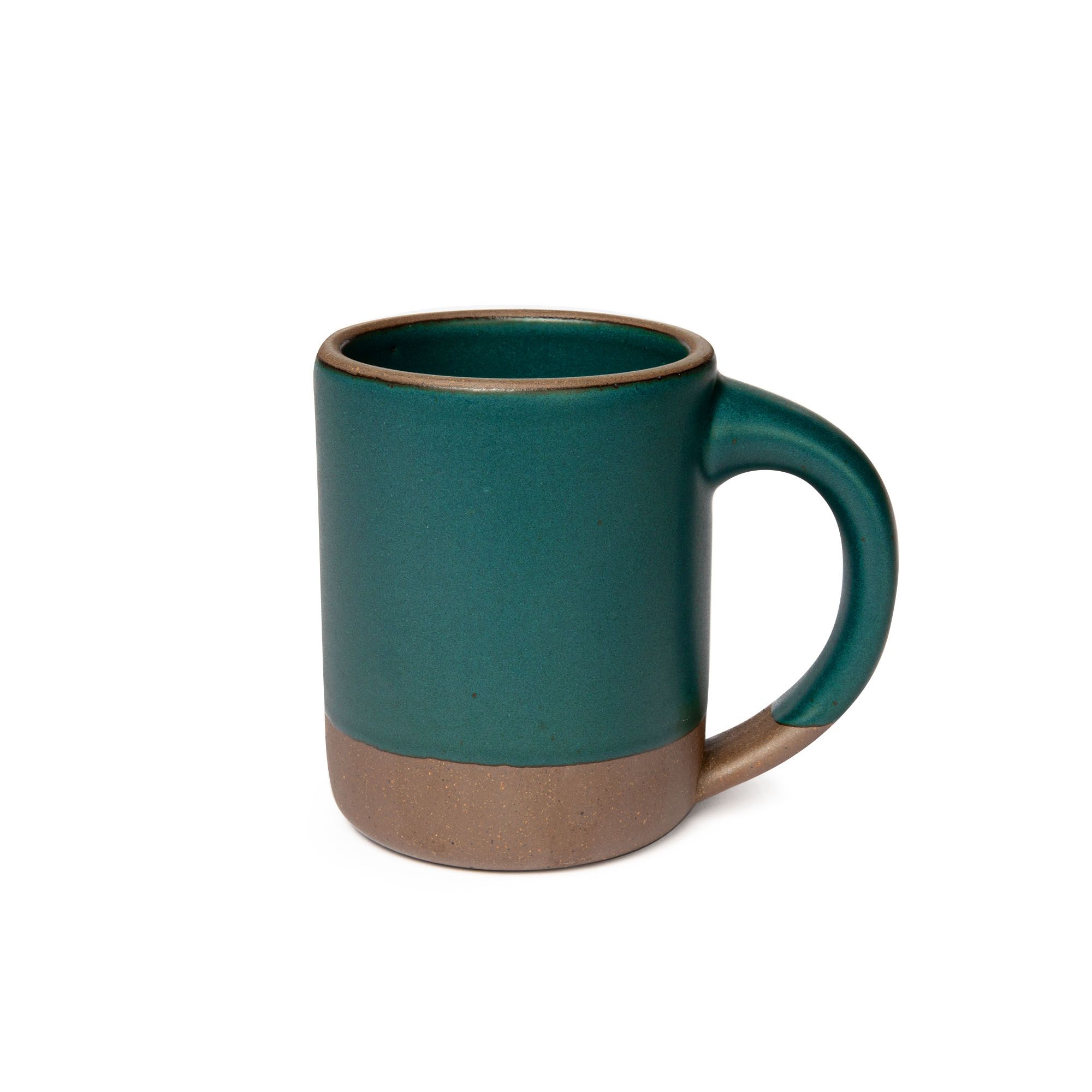A big sized ceramic mug with handle in a deep, dark teal color featuring iron speckles and unglazed rim and bottom base.
