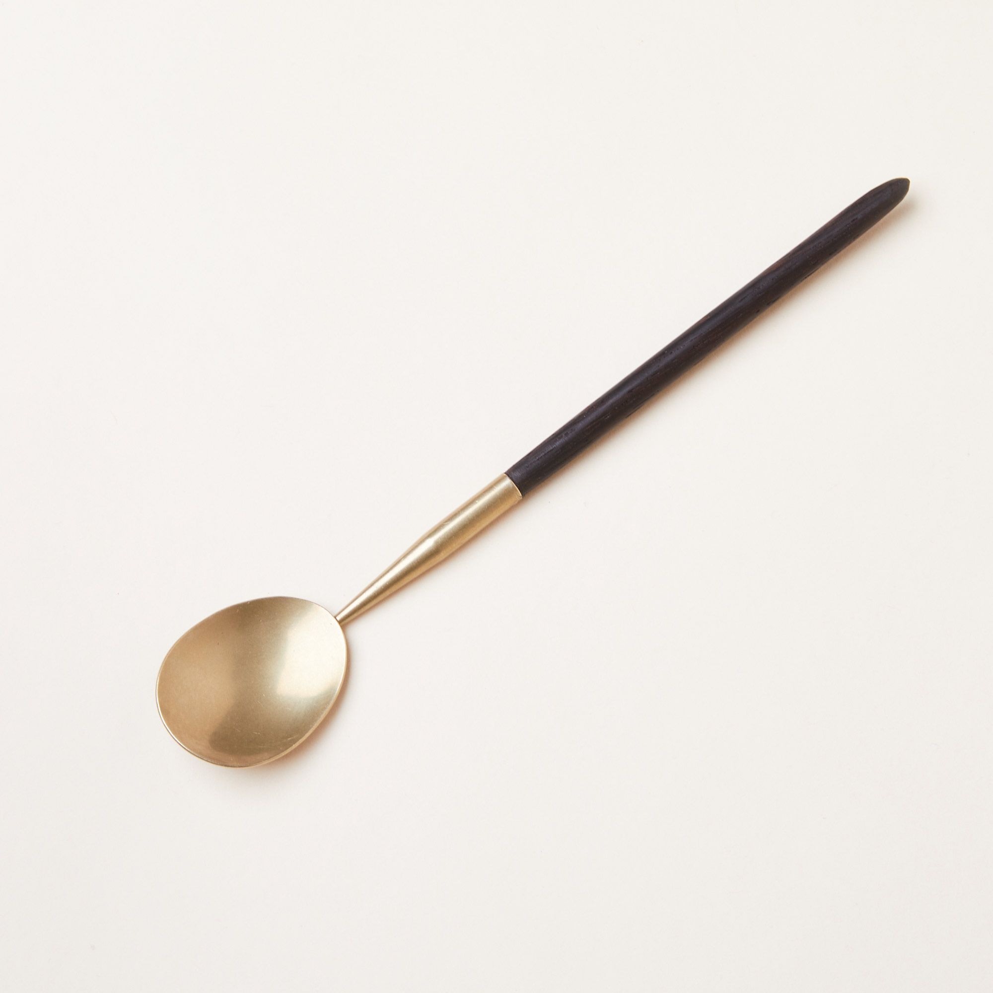 A long-handled spoon with brass ferrule and bowl