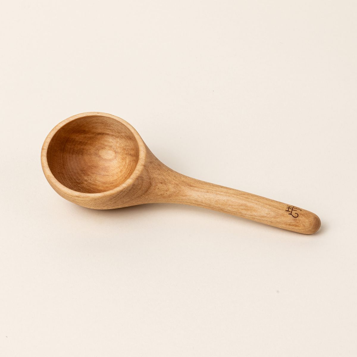 A short wooden coffee scoop with an East Fork logo stamp