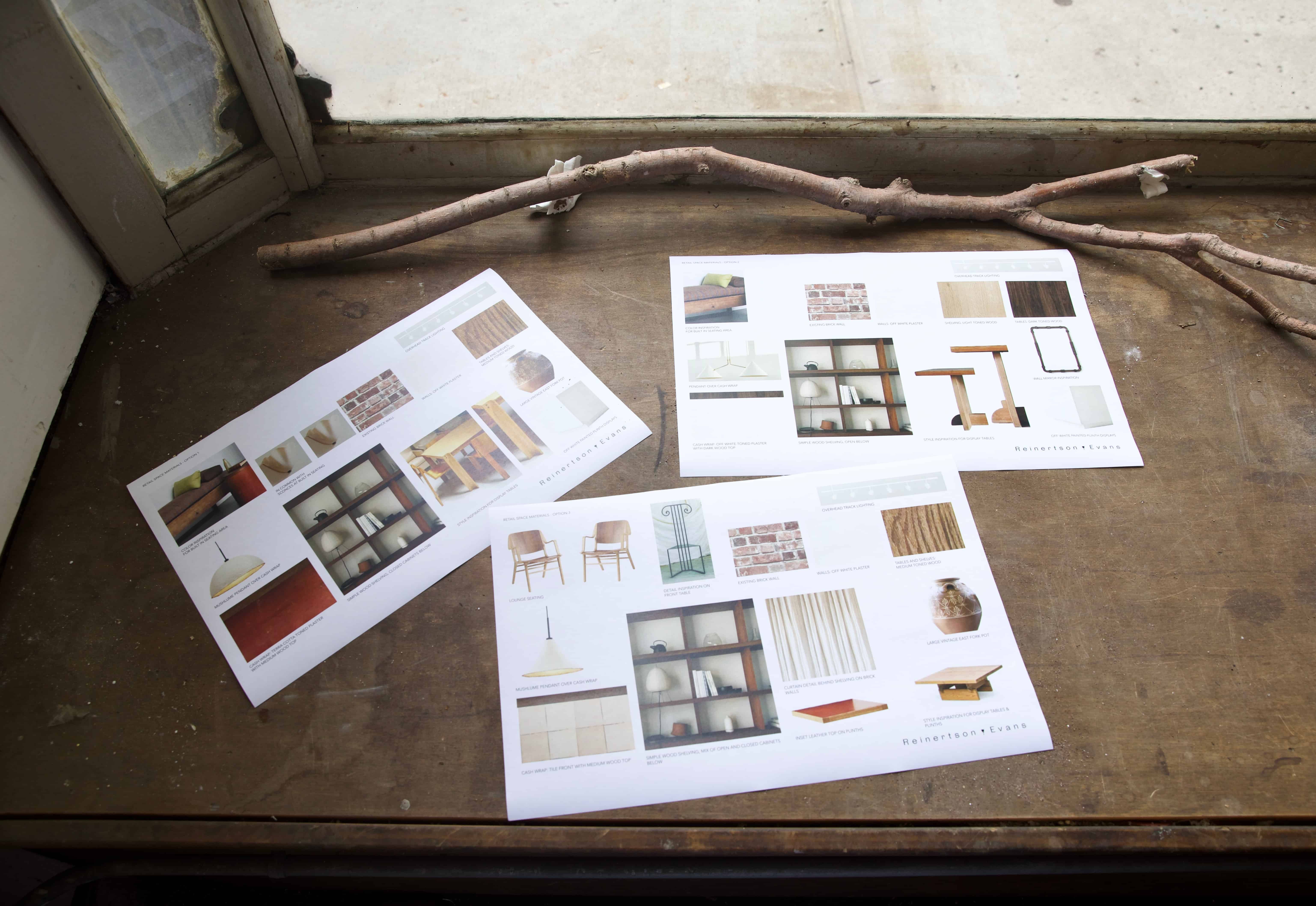 Printed mood boards for the store laid out on a window sill.