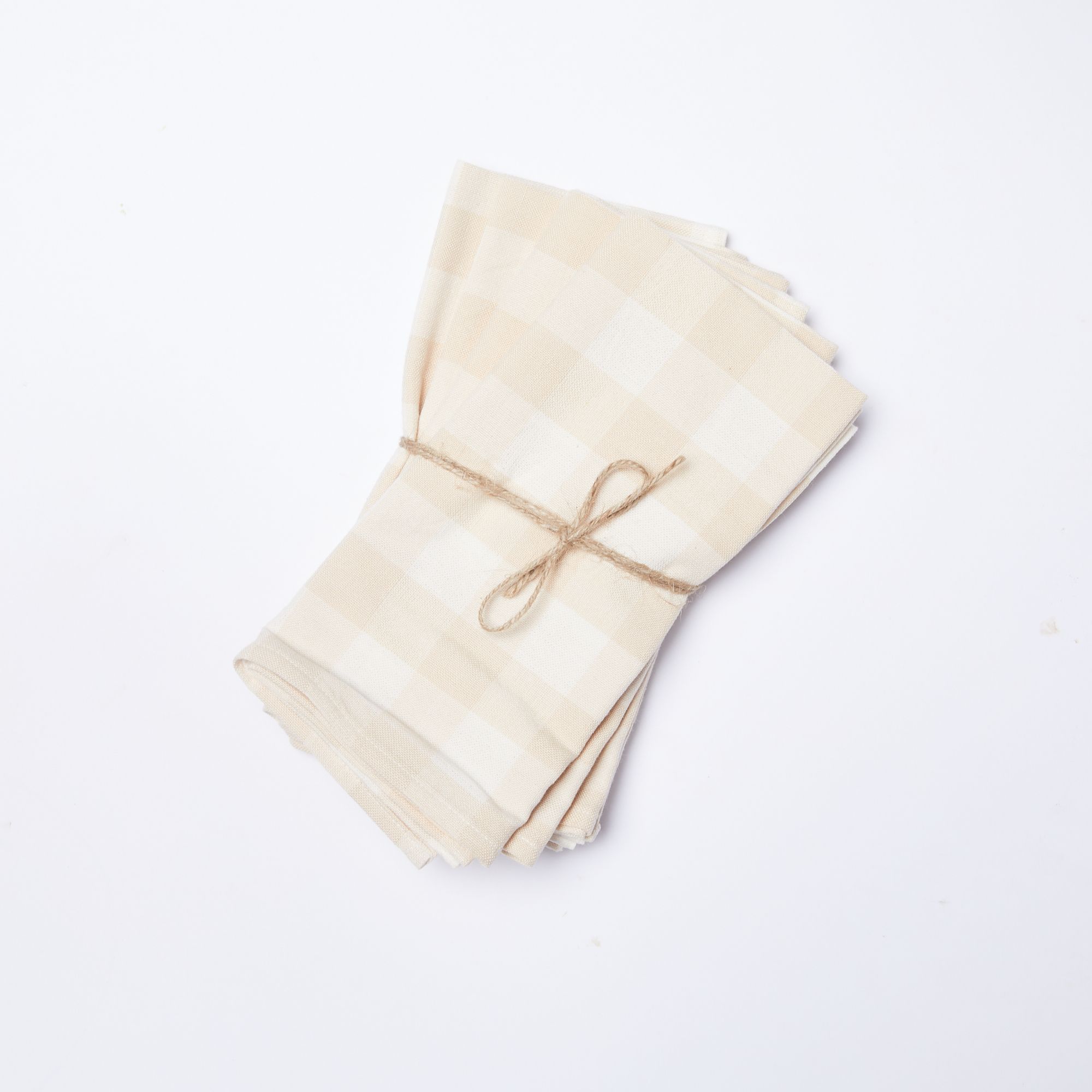 Stack of four cream and white gingham cotton napkins tied with a string