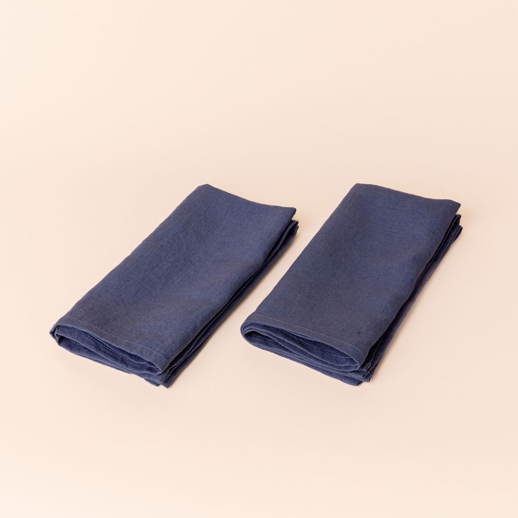 Two muted blue linen napkins folded into rectangles side by side