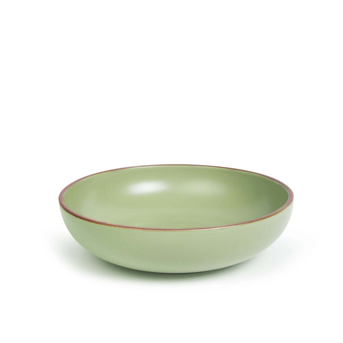 A large shallow serving ceramic bowl in a calming sage green color featuring iron speckles and an unglazed rim.