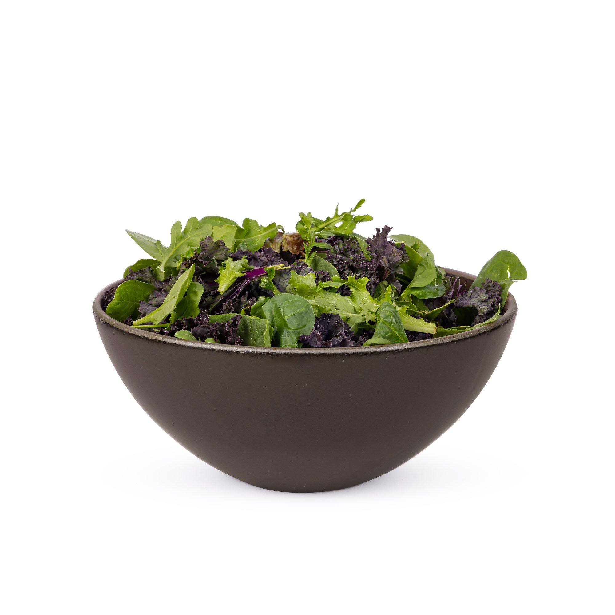 Salad in a large ceramic mixing bowl in a dark cool brown color featuring iron speckles and an unglazed rim