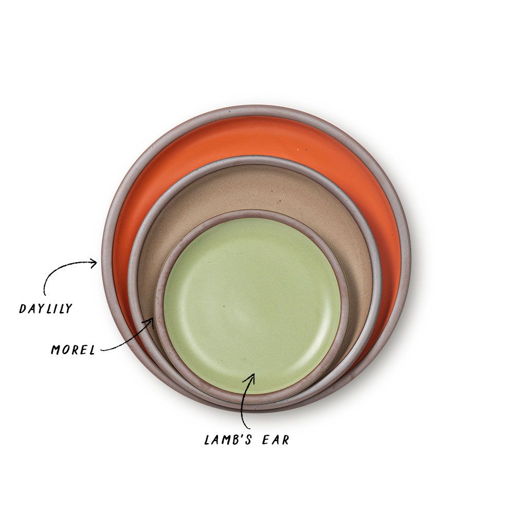 A stack of ceramic plates in a bold orange, muted tan, and calming sage green colors.