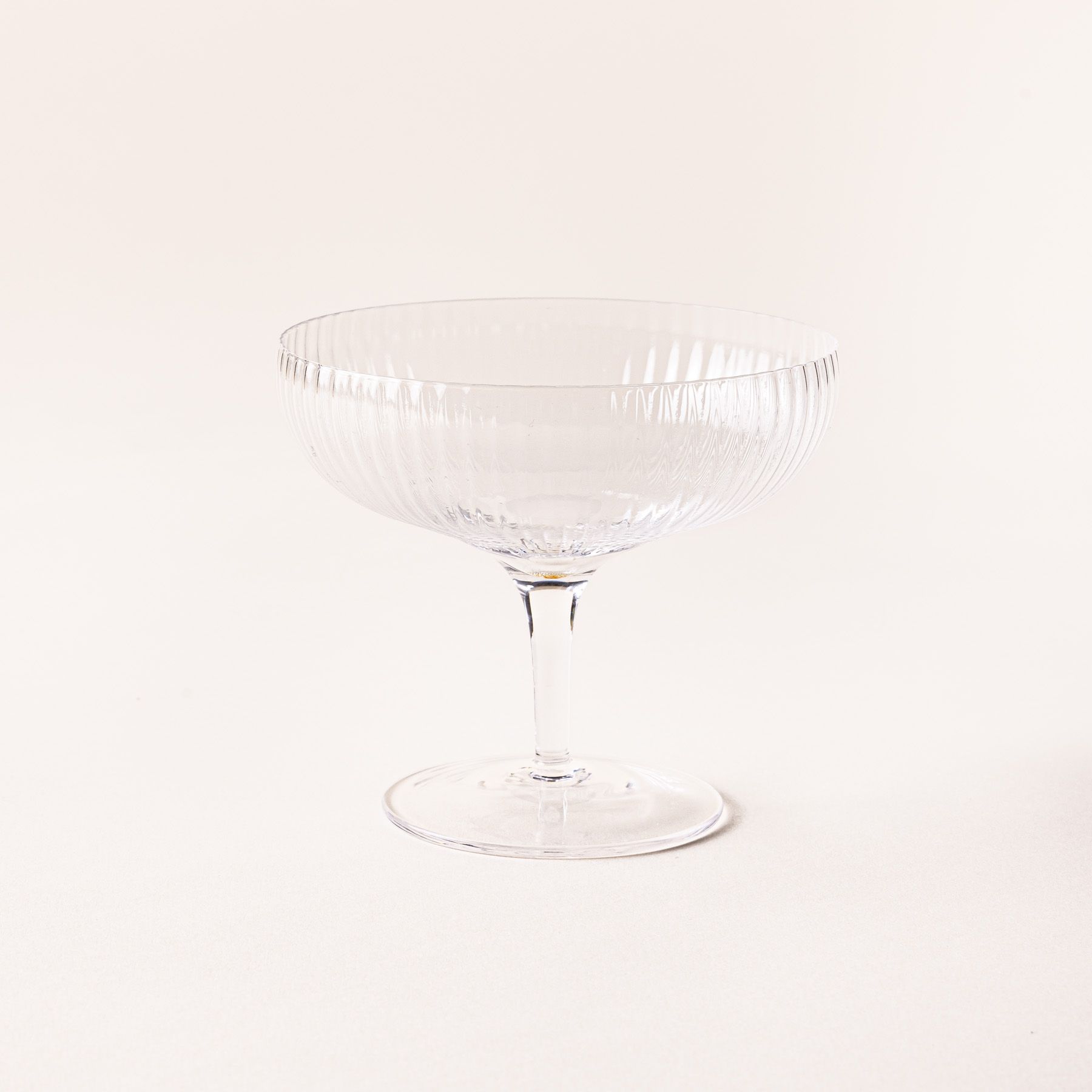 A delicate ribbed short coupe glass in the traditional style