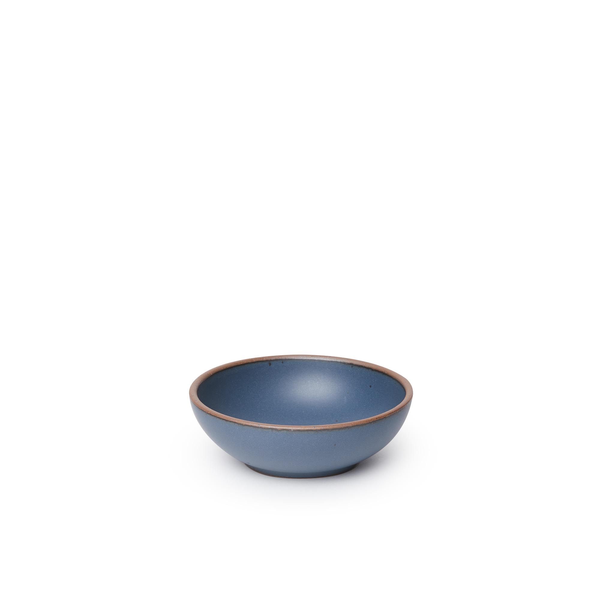 A small shallow ceramic bowl in a toned-down navy color featuring iron speckles and an unglazed rim
