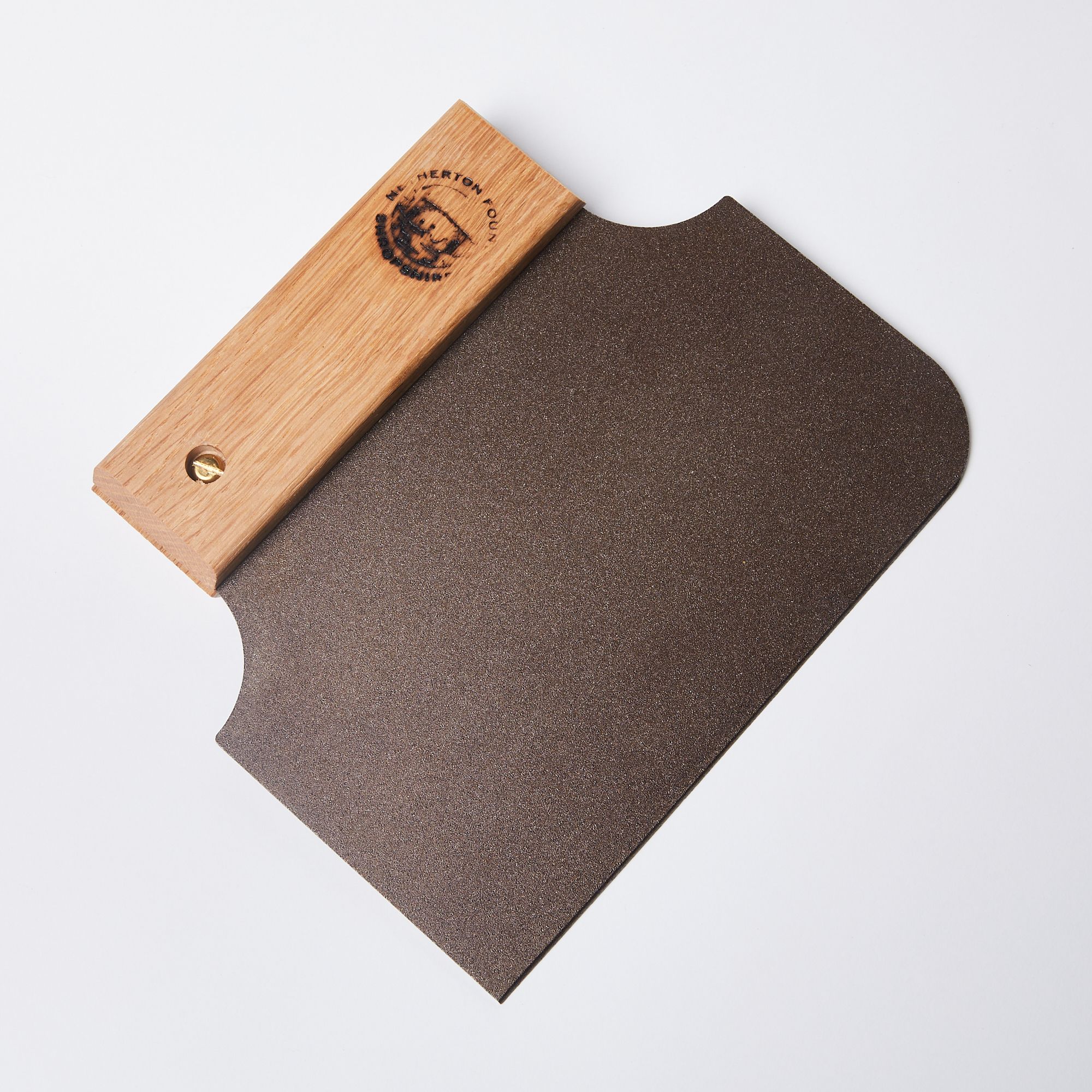 A black metal bench scraper with one rounded corner on the blade end while the handle end tapers in to a narrow wooden handle