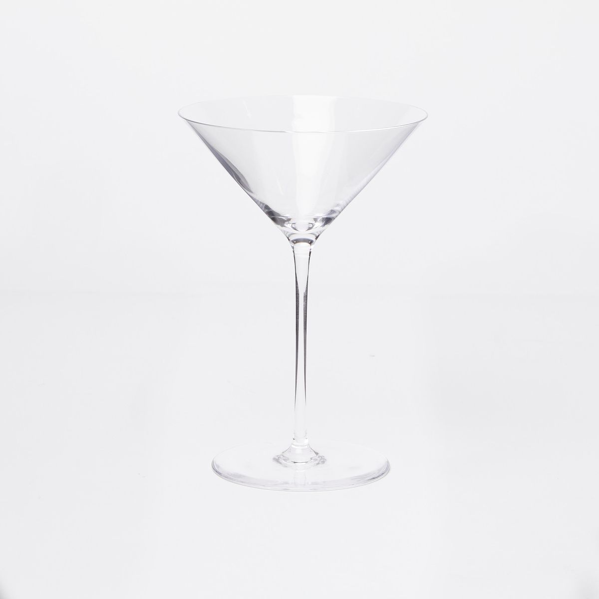A clear empty martini glass on a white background