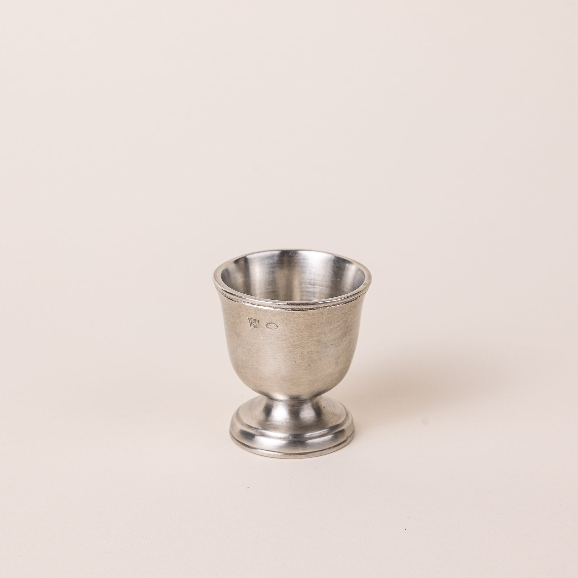 Traditional egg cup in a silver pewter and shaped like a small goblet.