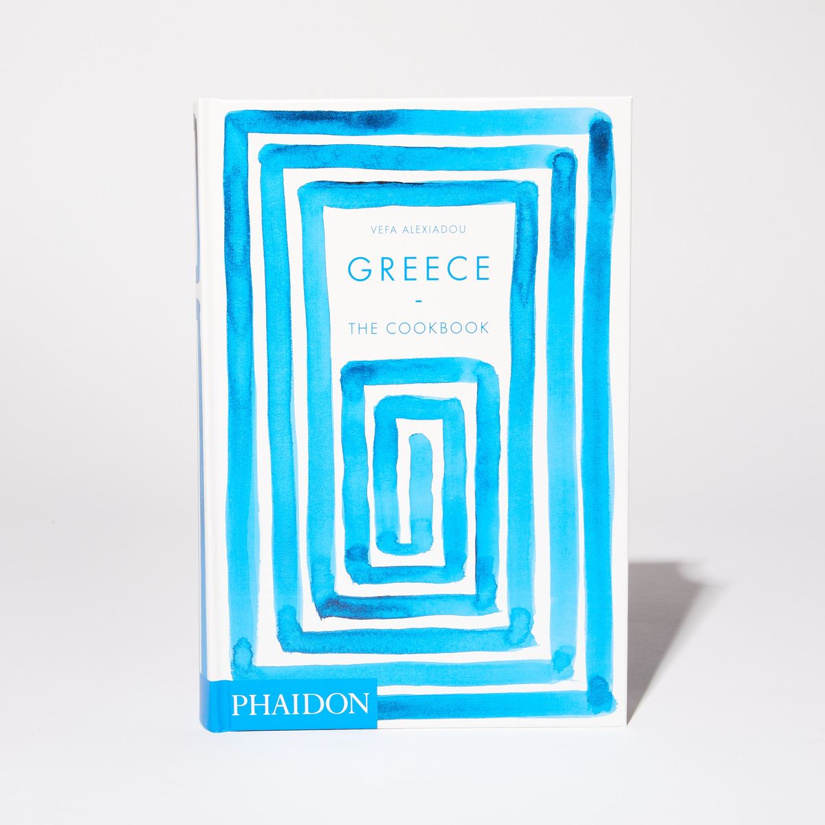 Book cover with hand-painted blue rectangular pattern with the title "Greece: The Cookbook"