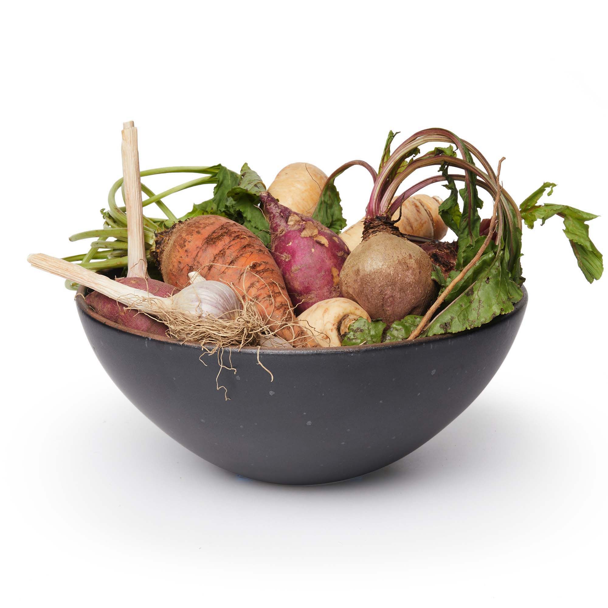 A dark charcoal bowl filled with root vegetables