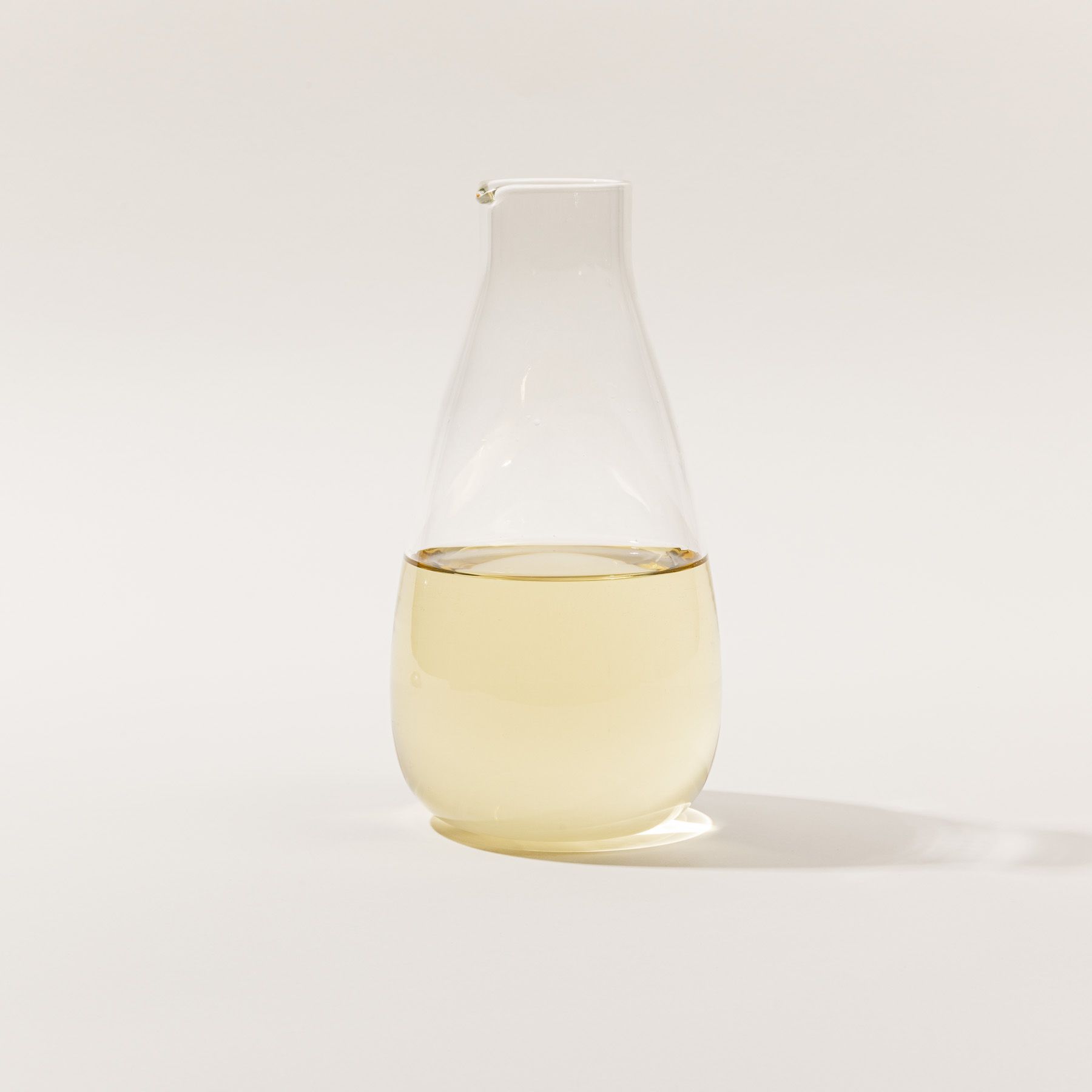 A simple elegant clear glass carafe filled with wine.