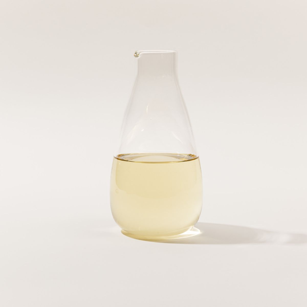 A simple elegant clear glass carafe filled with wine.