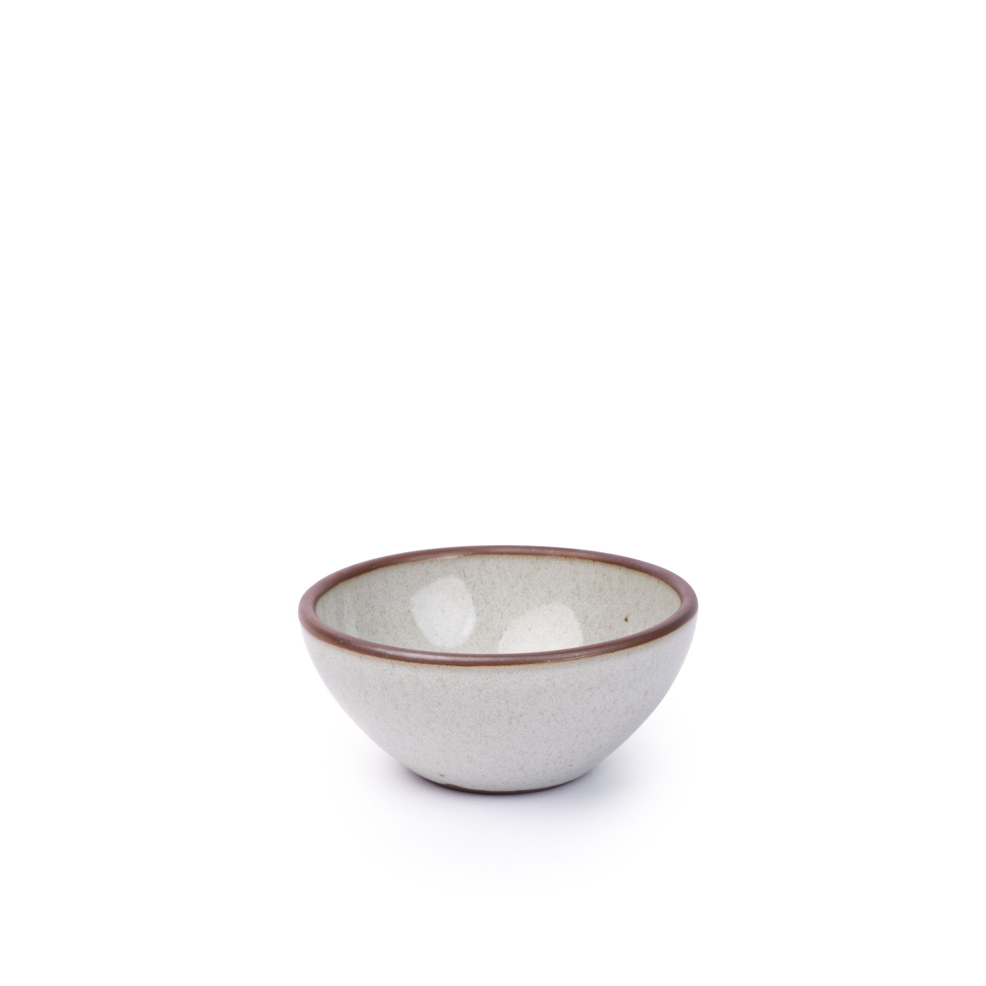 A small dessert sized rounded ceramic bowl in a reflective icy off-white color featuring iron speckles and an unglazed rim