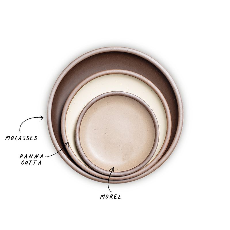 A stack of 3 plates in Dinner, Side, and Cake sizes in a dark brown, warm off-white, and warm beige colors.